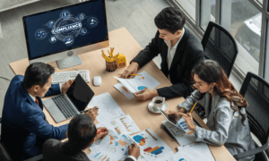 Four people sitting around a table looking at charts