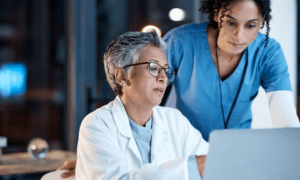 Two medical workers looking at a computer.